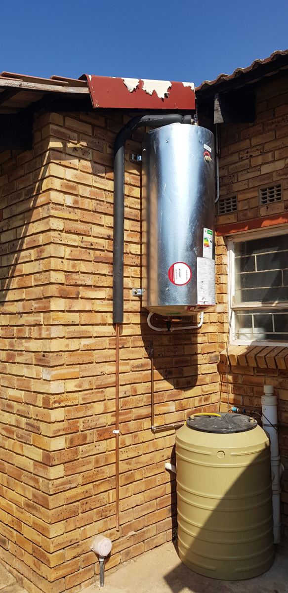 New Ariston vertical geyser mounted on an outside brick wall, with insulated hot-water pipe and copper supply